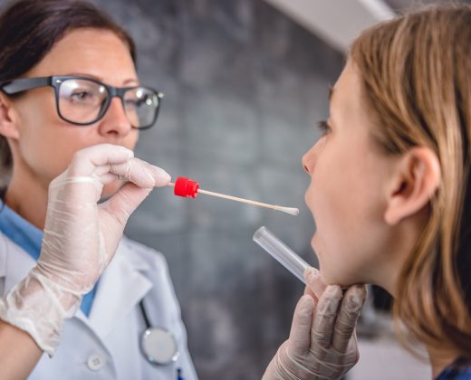 Female pediatrician using a swab to take a sample from a patient's throat